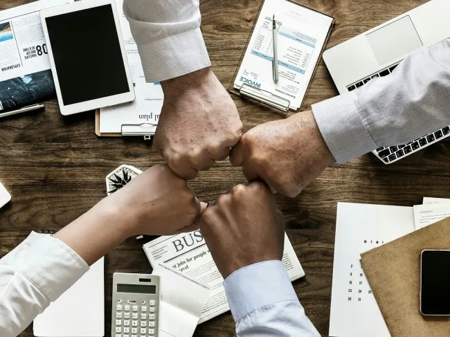Various hands touching in an office setting